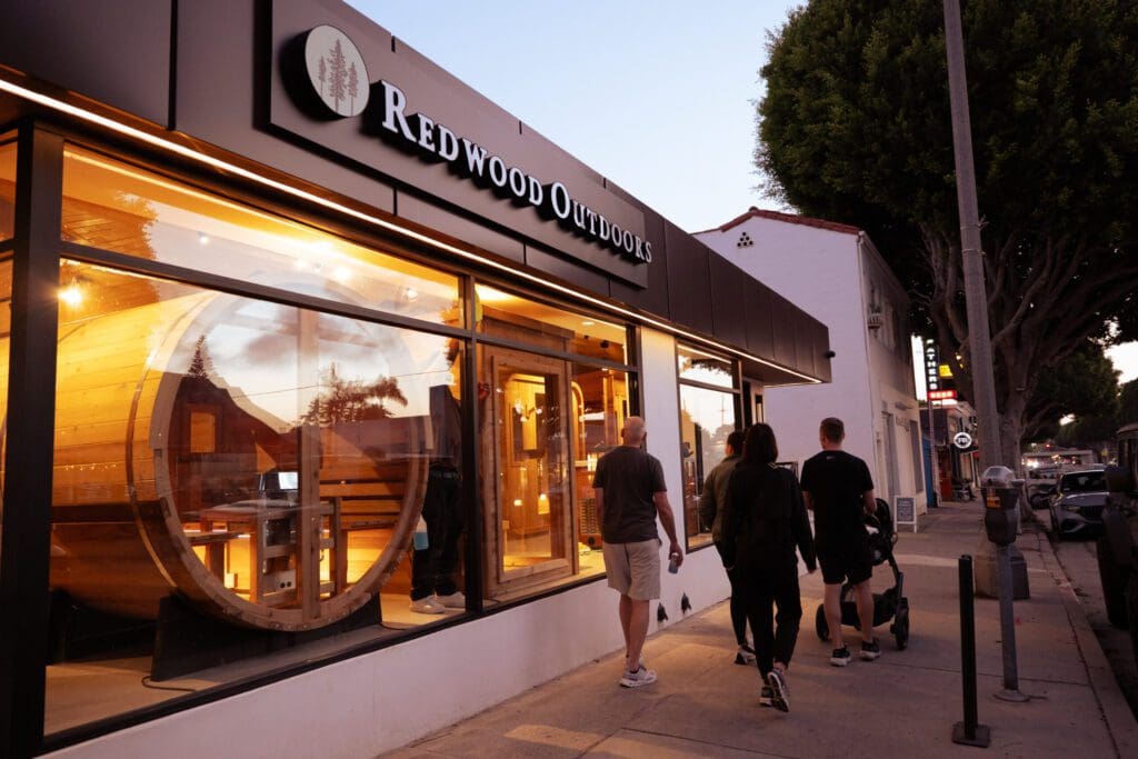 People walking past Redwood Outdoors store.