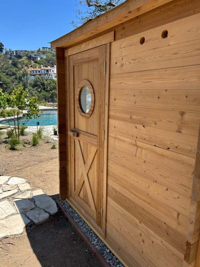 Custom backyard sauna with panoramic glass window and cedar wood exterior