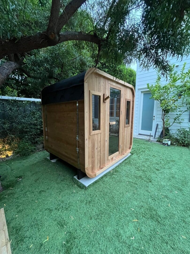 Cedar cube sauna in backyard under tree