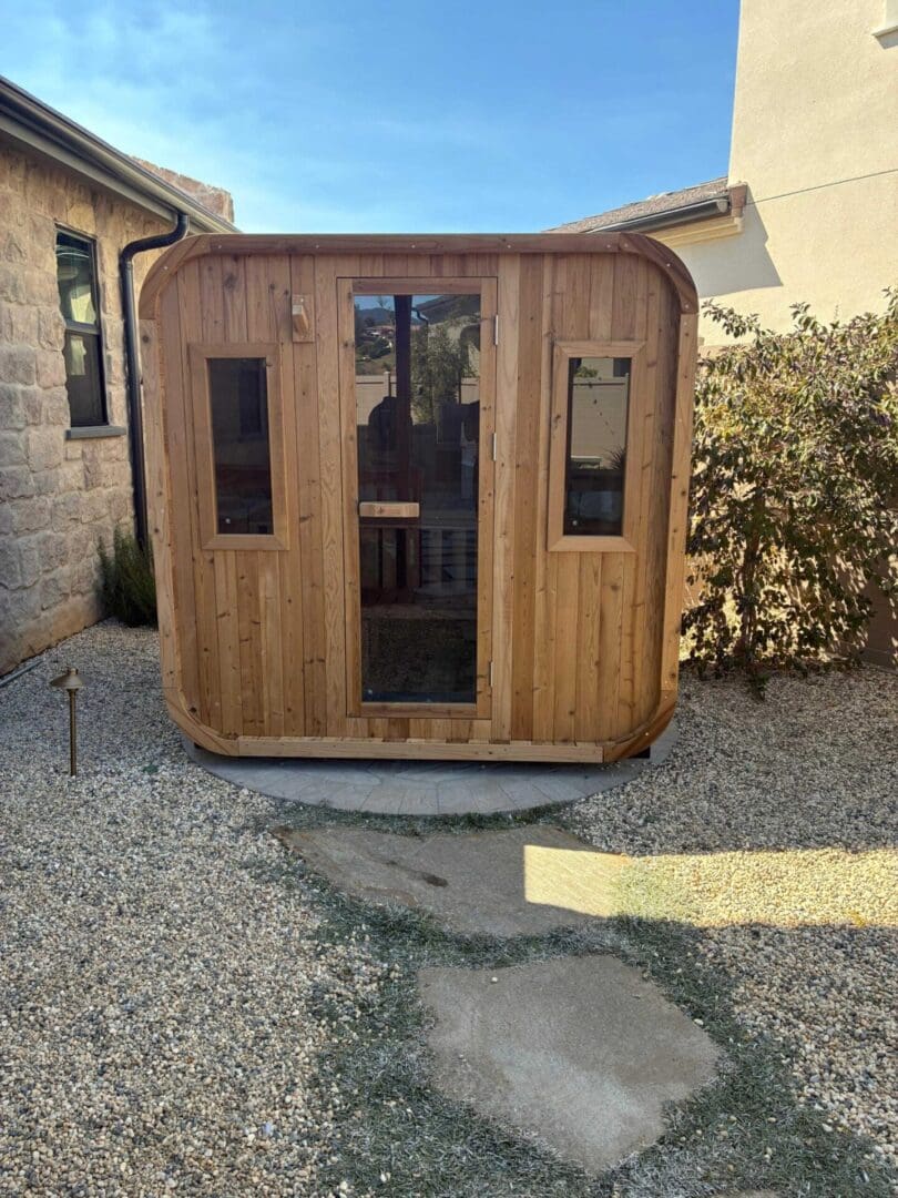 Square cedar outdoor sauna with gravel base